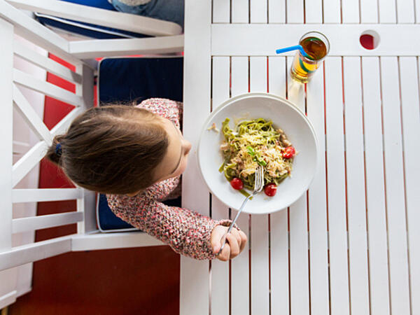 little girl eating dinner in restaurant